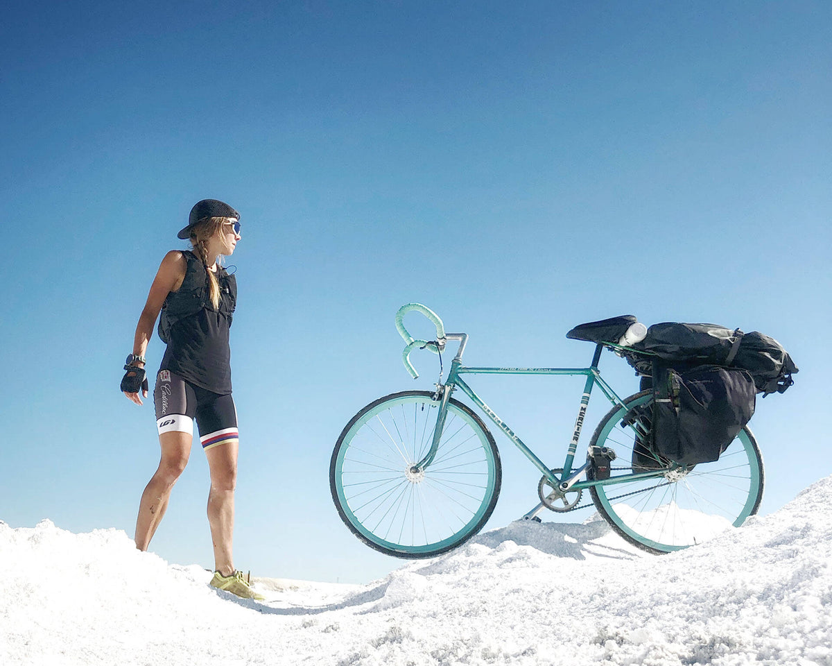 Caroline Côté, fuelled by HOLOS, standing tall next to her vintage Mercier single-speed bicycle